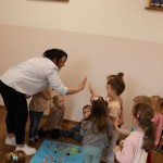 Powiększ zdjęcie Dzieci przybijają piątkę z panią w błękitnej koszuli