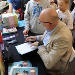 Powiększ zdjęcie Autor podpisuje książki 