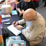 Powiększ zdjęcie Autor podpisuje książki dzieciom