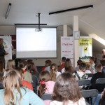 Powiększ zdjęcie Mężczyzna z długimi włosami, wyświetlona prezentacja i uczniowie
