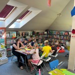 Powiększ zdjęcie Dzieci na warsztatach w bibliotece wykonują pracę plastyczną