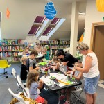 Powiększ zdjęcie Dzieci na warsztatach w bibliotece wykonują pracę plastyczną