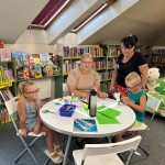 Powiększ zdjęcie Dzieci na warsztatach w bibliotece wykonują pracę plastyczną