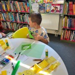 Powiększ zdjęcie Dziecko na warsztatach w bibliotece wykonują pracę plastyczną