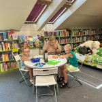 Powiększ zdjęcie Dzieci na warsztatach w bibliotece wykonują pracę plastyczną