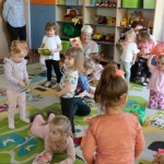 Powiększ zdjęcie Dzieci siedzą na dywanie i oglądają książki