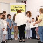 Powiększ zdjęcie Kobieta wręcza dzieciom prezenty