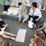 Powiększ zdjęcie Dzieci układają opis pingwina na podłodze