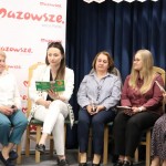Powiększ zdjęcie Pięć kobiet siedzi na krzesłach jedna czyta książkę