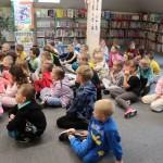 Powiększ zdjęcie Dzieci siedzą na podłodze w bibliotece 