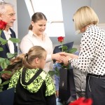 Powiększ zdjęcie Pani dyrektor wręcza różę kobiecie